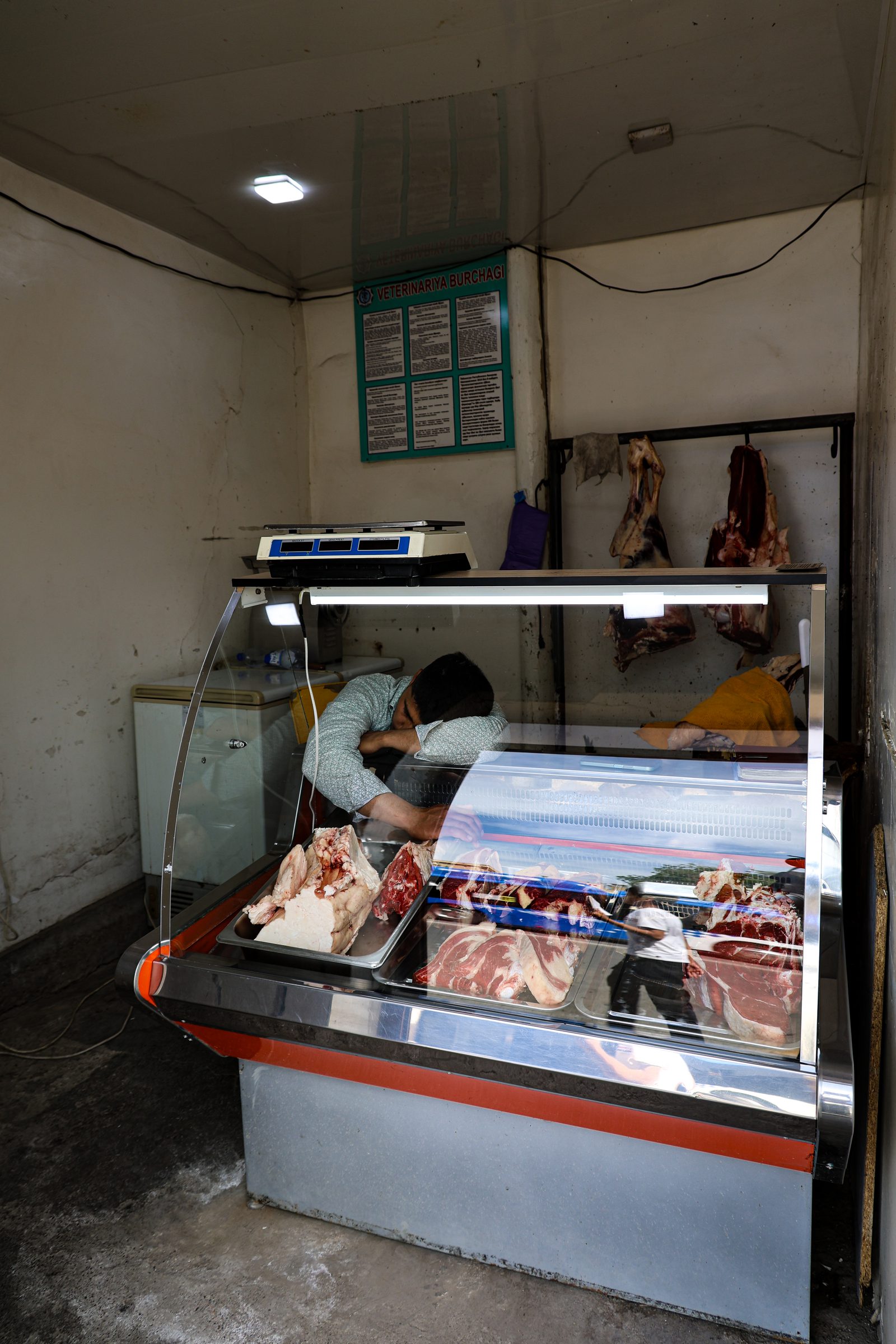 A vendor resting inside a butcher's display case